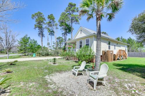 a house with two chairs and a palm tree at Lovely Carrabelle Home with Lake Views and Pool Access in Carrabelle