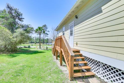 a porch with a wooden staircase on the side of a house at Lovely Carrabelle Home with Lake Views and Pool Access in Carrabelle