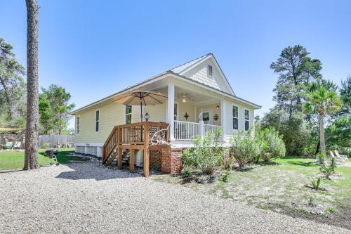 a house with a porch with an umbrella at Lovely Carrabelle Home with Lake Views and Pool Access in Carrabelle