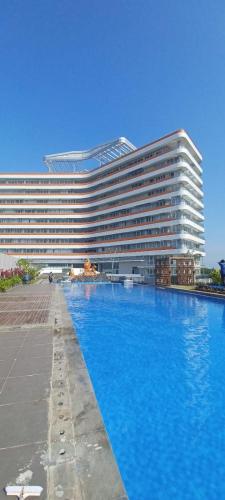 un grande edificio con una grande piscina di fronte di Sunset Seaview Family Room Nuvasa Bay Nongsa 719 a Nongsa