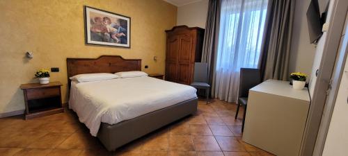 a bedroom with a bed and a table and a window at Agriturismo Le Arcate in Sinio