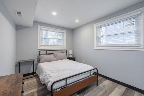 a bedroom with a bed and two windows at MODERN Updated Rare 2BR Condo in Washington
