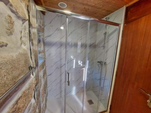 a shower with a glass door in a bathroom at Casa Ti' Beites, no Santuário de Nossa Senhora da Peneda in Arcos de Valdevez