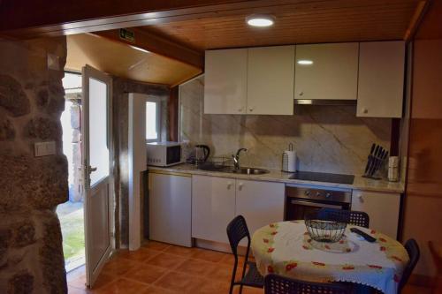 a kitchen with a table and a table and chairs at Casa Ti' Beites, no Santuário de Nossa Senhora da Peneda in Arcos de Valdevez