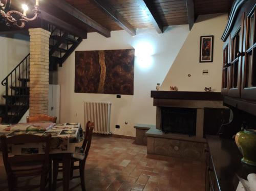 een woonkamer met een tafel en een open haard bij B&B del Fernè in Monte Ombraro