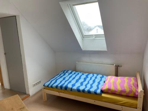 a small bed in a room with a window at Haus Dambacher - Arbeiter-Monteurzimmer in Nürtingen