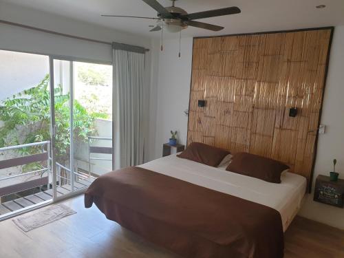 a bedroom with a large bed with a ceiling fan at Casa Piscis Spa in Taganga