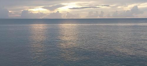 a view of a large body of water with the sun setting at POSADA ALEENY in Providencia