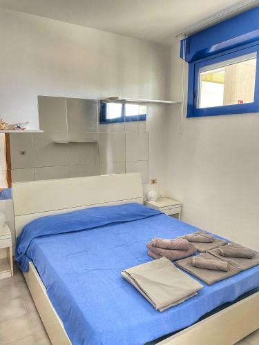 - un lit avec des draps bleus et des serviettes dans l'établissement Grazioso Appartamento n 71 a 100mt dal mare a Bibione, à Bibione