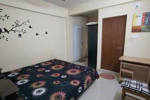 een slaapkamer met een bed met een bloemenpatroon aan de muur bij Sree Sai Guruvayoor in Guruvāyūr