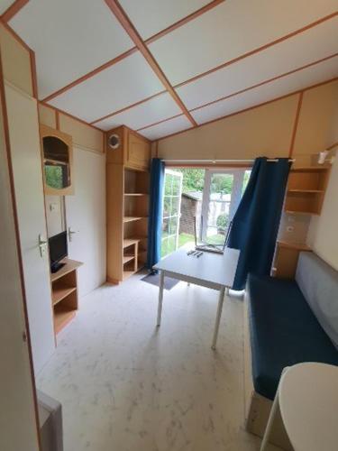 a room with a table and a chair in a house at Camping Le Mont César in Gouvieux