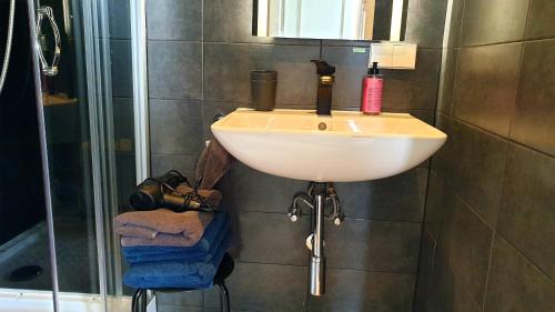 a white sink in a bathroom with a shower at Amor Guesthouse in Amsterdam