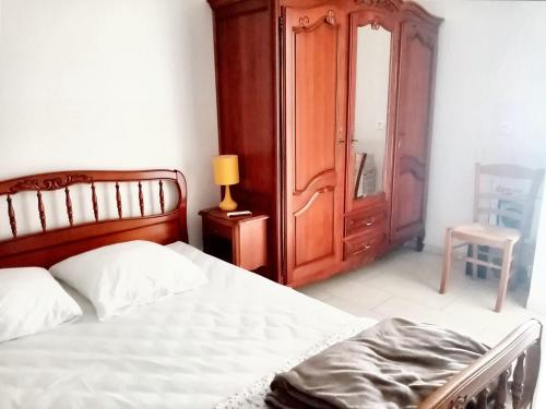 a bedroom with a bed and a cabinet and a chair at Maison d'une chambre avec jardin clos et wifi a Tonnay Charente in Tonnay-Charente