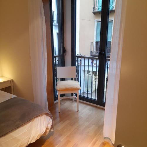 a bedroom with a chair and a balcony at Bardenas de Tudela in Tudela