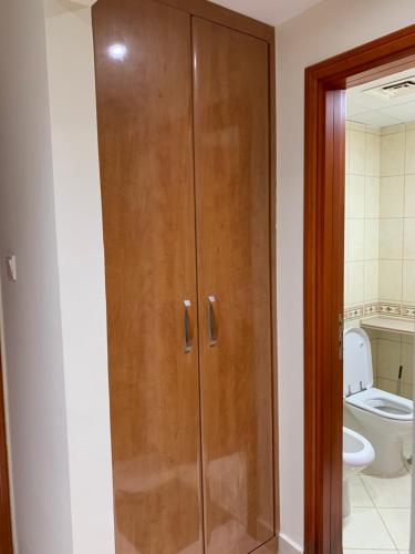 a wooden cabinet in a bathroom with a toilet at Stanley Hostel in Dubai