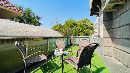 a group of chairs sitting on a balcony at BluO 3BHK Green Park, Private Garden Lift - Balcony in New Delhi