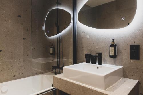 a bathroom with a sink and a shower and a mirror at Wood (Forestia) in Theux