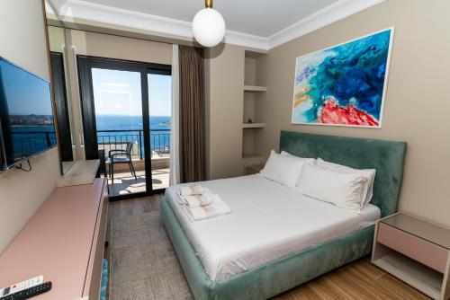 a bedroom with a bed and a balcony at Blissful Apartments in Sarandë