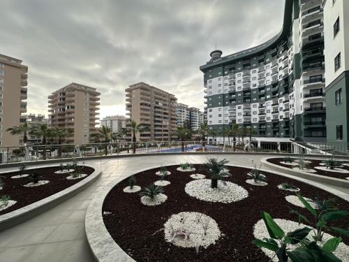 un bâtiment avec une cour ornée de fleurs et de plantes dans l'établissement serenityrecidencesitesi, à Alanya