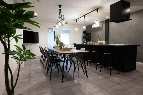 a dining room and kitchen with a table and chairs at tomo 非日常の暮らし 広い浴室サウナ付き 寝室6つ ベッド11台 関西空港直通の最寄り駅 in Osaka