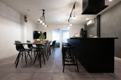 a kitchen and dining room with a table and chairs at tomo 非日常の暮らし 広い浴室サウナ付き 寝室6つ ベッド11台 関西空港直通の最寄り駅 in Osaka