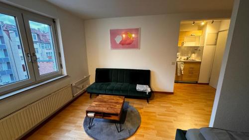 a living room with a green couch and a coffee table at Apartment 1 im Lehenviertel in Stuttgart