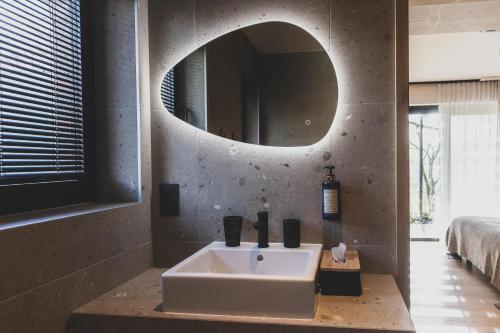 a bathroom with a white sink and a mirror at Wood (Forestia) in Theux