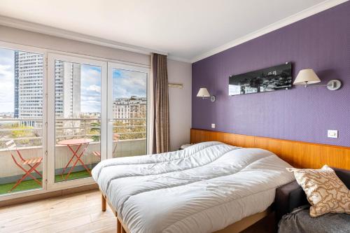 um quarto com uma cama e uma grande janela em GuestReady - Charming Stay near La Défense em Courbevoie