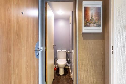 un piccolo bagno con servizi igienici e una foto di GuestReady - Charming Stay near La Défense a Courbevoie