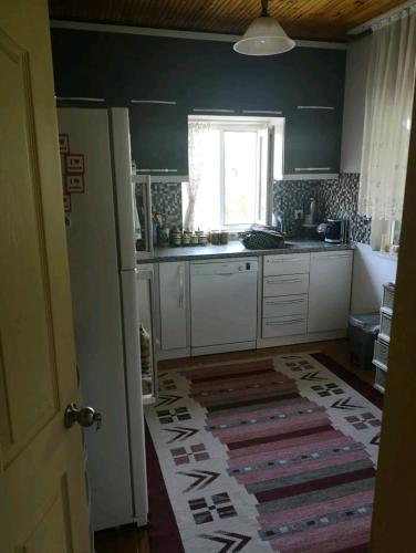 a kitchen with a white refrigerator and a window at Canerbey Çiftlik Dağ Evi 2 in Ovacık