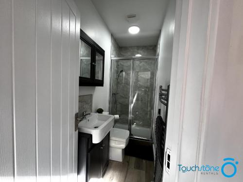 La salle de bains est pourvue d'un lavabo, d'une douche et de toilettes. dans l'établissement Beautiful Apartment for solo and couple travellers, à Sheldon