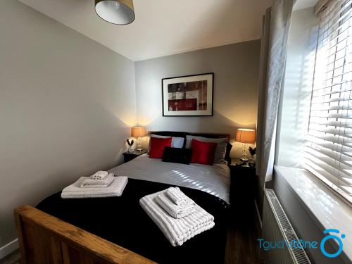 - une petite chambre avec un lit et des oreillers rouges dans l'établissement Beautiful Apartment for solo and couple travellers, à Sheldon