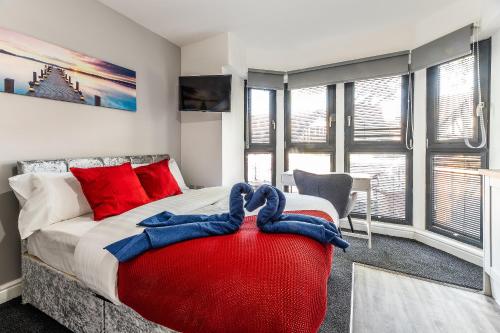 1 dormitorio con 1 cama grande con almohadas rojas y azules en Stay Sleep Rest - Derby Road, en Nottingham