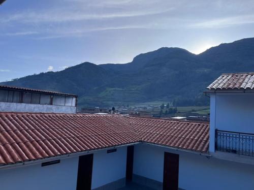 a view of the mountains from the roofs of two buildings at Hotel Restaurante Minas Cocha in Chavín de Huantar