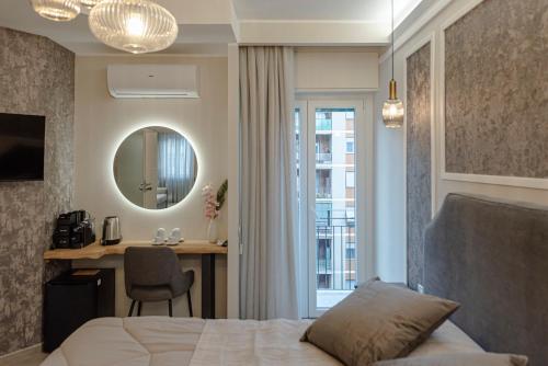 um quarto com uma cama, uma secretária e um espelho em Il Narciso em Roma