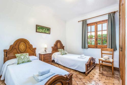 een slaapkamer met 2 bedden en een raam bij Villa Jalima in Son Carrio