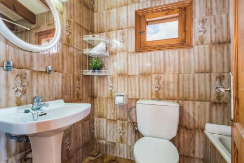 een badkamer met een toilet, een wastafel en een spiegel bij Villa Jalima in Son Carrio