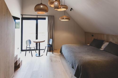 a bedroom with a bed and a table and chairs at Wood (Forestia) in Theux