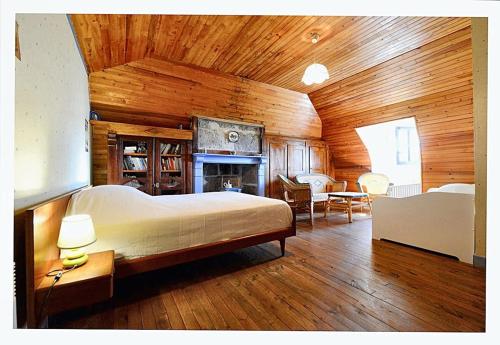 ein Schlafzimmer mit einem großen Bett und einem Kamin in der Unterkunft Maison de 2 chambres avec jardin clos a Le Fau in Le Fau