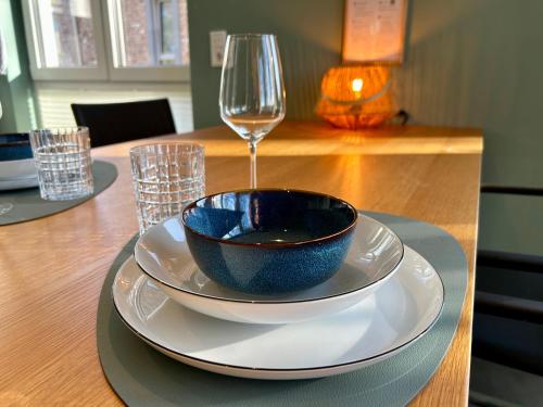 a bowl on a plate on a table with a glass at LITELIVING Cozy Suite - Sauna - Balkon - Parken - BBQ - Modern & Gemütlich in Möhnesee