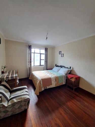 een slaapkamer met een bed en een bank bij Spanish Friends in Sucre