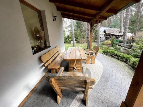 Una mesa de madera y bancos en un patio. en Sunny Home Turawa, en Turawa