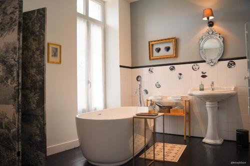 uma casa de banho com uma banheira e um lavatório em La Villa Marguerite em Périgueux