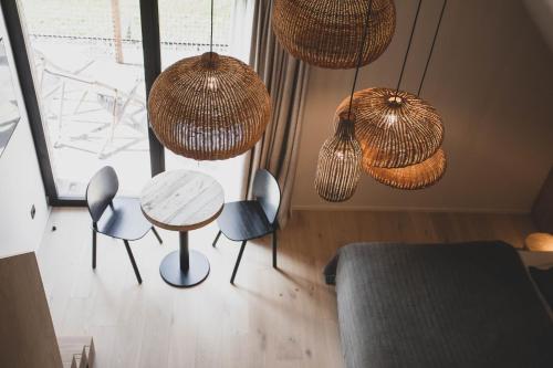 a room with a table and chairs and lights at Wood (Forestia) in Theux