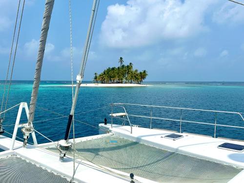 un bateau dans l'océan avec une île en arrière-plan dans l'établissement "Marea" Sunreef 62 Catamaran with Crew all inclusive, à Isla Wichitupo Grande