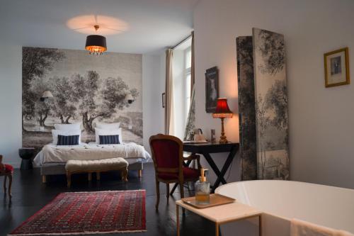 una camera con letto e tavolo con scrivania di La Villa Marguerite a Périgueux
