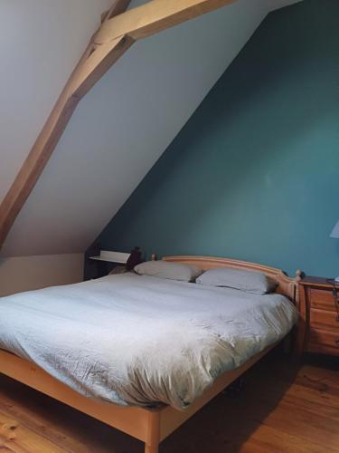 1 dormitorio con 1 cama con pared azul en Chambre double à la campagne en Verchin