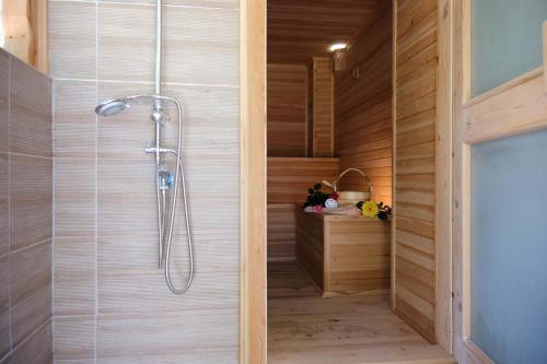 y baño con ducha y paredes de madera. en Vahide Homes, en Doger Koyu