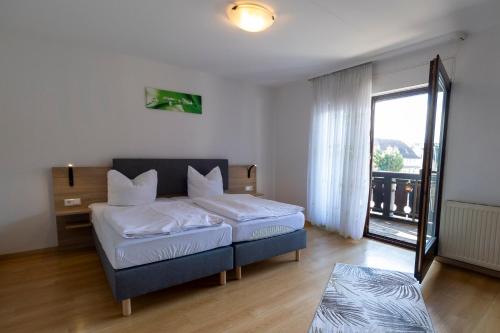 a bedroom with a bed and a large window at Hotel Landgasthaus Rössle in Hofweier