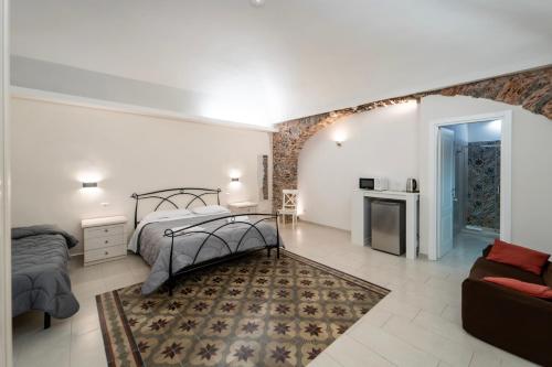 una camera da letto con un letto e un divano di BELLINIKATANESUITE a Catania